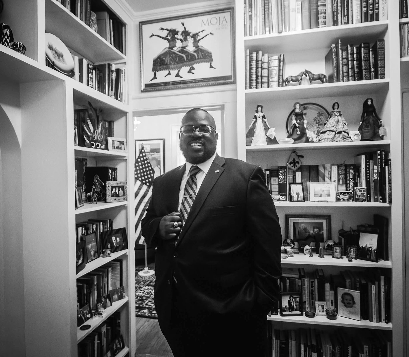 Montez Aiken in a suit and tie, standing in a home library